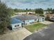 Aerial view of a charming single-story home featuring a bright exterior, solar panels and a well-maintained lawn at 253 Blackwell Villa Cv, Babson Park, FL 33827