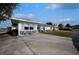 Side exterior view of the house with a large concrete parking area at 253 Blackwell Villa Cv, Babson Park, FL 33827