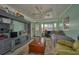 Living room with green walls, ceiling fan, large entertainment center, wood coffee table, and bay window at 253 Blackwell Villa Cv, Babson Park, FL 33827