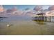 Beautiful waterfront view of a pier on a lake at sunset at 253 Blackwell Villa Cv, Babson Park, FL 33827