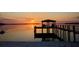 Beautiful view of a waterfront home with a beach, dock, and lake access at sunset at 253 Blackwell Villa Cv, Babson Park, FL 33827