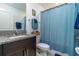 Bathroom featuring a granite vanity, stainless steel hardware, and shower with a blue curtain at 2566 Red Egret Dr, Bartow, FL 33830