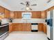 Traditional kitchen with wooden cabinetry, white countertops, and appliances, bathed in natural light at 309 S 5Th St, Lake Wales, FL 33853