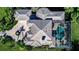 Aerial view of home featuring tile roof, screened pool, circular driveway, and beautiful landscaping at 3312 Eagles Trce, Winter Haven, FL 33884