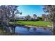 View of the home's large manicured lawn and screened-in pool, backing to the water at 3312 Eagles Trce, Winter Haven, FL 33884