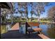 Expansive backyard featuring a dock on the water, lush greenery, and a glimpse of the home at 3312 Eagles Trce, Winter Haven, FL 33884