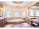 Elegant bathroom features a large tub, chandelier, and vanities, and marble floors at 3312 Eagles Trce, Winter Haven, FL 33884