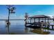 Scenic lake view showcasing a private dock with a covered area for relaxing and enjoying the water at 3312 Eagles Trce, Winter Haven, FL 33884