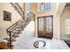 Elegant foyer with a grand staircase, decorative tile, and custom wood double doors at 3312 Eagles Trce, Winter Haven, FL 33884