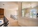 Upstairs hallway featuring a decorative railing and glass door leading to fitness space at 3312 Eagles Trce, Winter Haven, FL 33884