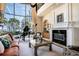 Elegant living room with fireplace, grand piano, and floor-to-ceiling windows showcasing a waterfront view at 3312 Eagles Trce, Winter Haven, FL 33884