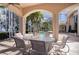 Covered outdoor patio with dining set provides an inviting space overlooking the pool and lake at 3312 Eagles Trce, Winter Haven, FL 33884