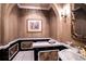 A stylish powder room featuring custom wallpaper, an ornate mirror, and a pedestal sink with gold accents at 3312 Eagles Trce, Winter Haven, FL 33884