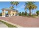 Welcoming community entrance gate featuring a brick-paved entryway, lush landscaping, and a charming guardhouse at 3418 Raleigh Dr, Winter Haven, FL 33884