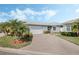 Inviting one-story home featuring a paved driveway, lush landscaping, and an attached two-car garage at 3418 Raleigh Dr, Winter Haven, FL 33884
