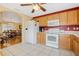 Cozy kitchen with wooden cabinets and white appliances, attached to dining and living areas at 3418 Raleigh Dr, Winter Haven, FL 33884