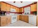 Bright kitchen features wooden cabinetry, white appliances, a window, and neutral tile flooring at 3418 Raleigh Dr, Winter Haven, FL 33884