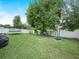 Well-kept backyard featuring green grass, a white fence, a trampoline, grill and basketball hoop at 3526 Warbler Way, Kissimmee, FL 34746