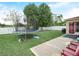 Spacious backyard with trampoline, grill, mature trees, and a white privacy fence for outdoor fun at 3526 Warbler Way, Kissimmee, FL 34746