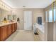 Bathroom with a double vanity, a relaxing jacuzzi tub, and a separate area for toiletries at 3526 Warbler Way, Kissimmee, FL 34746