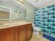 The bathroom features a shark-themed shower curtain, matching wall decor, and tile flooring at 3526 Warbler Way, Kissimmee, FL 34746