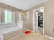 Bathroom featuring a soaking tub, separate shower, and an open doorway to a walk-in closet at 3526 Warbler Way, Kissimmee, FL 34746