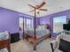 Bedroom featuring purple walls, a four-poster bed, and carpet flooring at 3526 Warbler Way, Kissimmee, FL 34746