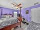 This bedroom includes a four-poster bed with purple walls, a ceiling fan, and carpet flooring at 3526 Warbler Way, Kissimmee, FL 34746