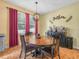 Cozy dining room featuring a wooden table, four chairs, and natural light from the windows at 3526 Warbler Way, Kissimmee, FL 34746