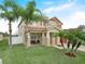 Inviting home featuring a covered porch, manicured lawn, beautiful plants and two-car garage at 3526 Warbler Way, Kissimmee, FL 34746