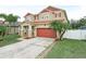 Two-story home featuring a two-car garage, manicured lawn, and appealing exterior with red accents at 3526 Warbler Way, Kissimmee, FL 34746