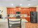 Well-equipped kitchen featuring wooden cabinetry, stainless steel appliances, and a breakfast bar area at 3526 Warbler Way, Kissimmee, FL 34746