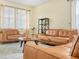 Bright living room with leather seating, neutral rug, and natural light at 3526 Warbler Way, Kissimmee, FL 34746
