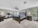 Spacious main bedroom featuring a ceiling fan, natural light, and stylish furnishings at 3526 Warbler Way, Kissimmee, FL 34746