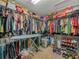 Well-organized walk-in closet with an ironing board, clothing racks, and plenty of shelving for shoes and storage at 3526 Warbler Way, Kissimmee, FL 34746