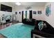 Living room with a black sofa, area rug, and modern decor for a cozy ambiance at 3750 Park Ave, Indian Lake Estates, FL 33855