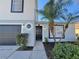 Two-story home featuring a black front door, a gray garage door, and lush landscaping at 3807 Mckinley Dr, Winter Haven, FL 33880