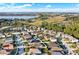 Scenic aerial view of a residential neighborhood with tidy lawns and streets, bordering natural landscape and a lake at 3828 Eloise Estates Ct, Winter Haven, FL 33881