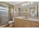 Bathroom featuring walk-in shower, wood cabinets, and neutral tile at 400 El Camino Dr # 101, Winter Haven, FL 33884