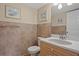 Half-bath with decorative tile, wood cabinets, and granite counters at 400 El Camino Dr # 101, Winter Haven, FL 33884