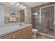 Bathroom featuring walk-in shower, wood cabinets, and neutral tile at 400 El Camino Dr # 101, Winter Haven, FL 33884