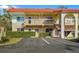 Two story condo building featuring red tile roof and well maintained landscaping at 400 El Camino Dr # 101, Winter Haven, FL 33884