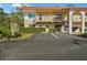 Wide view of the condo highlighting the multiple units, parking, and red tile roof at 400 El Camino Dr # 101, Winter Haven, FL 33884