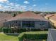 Aerial perspective of a house showing the screened-in pool and patio, and backyard view with trees at 4033 Phoenician Way, Winter Haven, FL 33884
