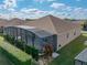 Aerial view of a home with screened-in pool and patio surrounded by a green backyard with hedges and trees at 4033 Phoenician Way, Winter Haven, FL 33884