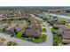 Expansive aerial view showcases the home's landscaping and its prime location near a picturesque pond and lush greenery at 4033 Phoenician Way, Winter Haven, FL 33884