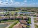 Scenic aerial shot highlighting the property's serene lakefront location amidst lush landscaping and well-maintained neighborhood at 4033 Phoenician Way, Winter Haven, FL 33884