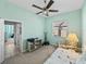 Cozy bedroom with large window, chair, ceiling fan, and storage shelves at 4033 Phoenician Way, Winter Haven, FL 33884
