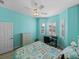 Bright bedroom with turquoise walls, plantation shutters, ceiling fan, and closet at 4033 Phoenician Way, Winter Haven, FL 33884