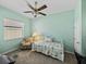 Cozy bedroom with large window, chair, ceiling fan, and comfortable bedding at 4033 Phoenician Way, Winter Haven, FL 33884